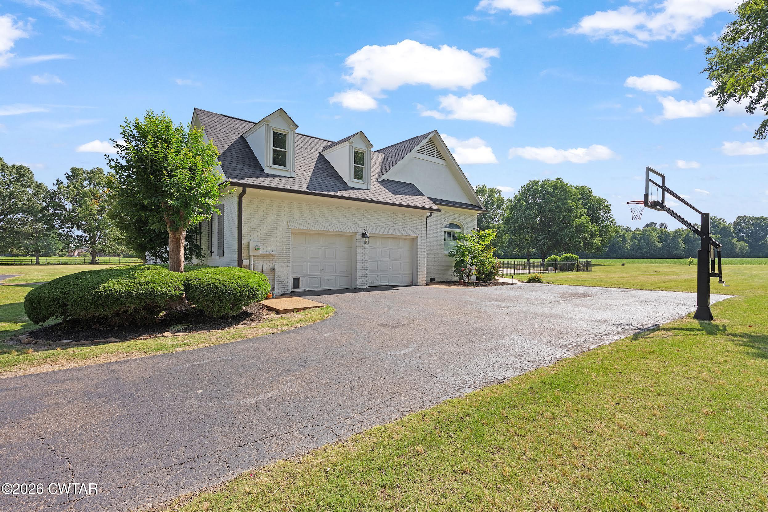 58 Huntington Place Jackson, TN 38305 - Photo 3 of 38 a view of a house with a big yard and large trees