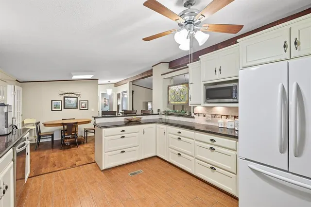 a kitchen with granite countertop cabinets a dining table and stainless steel appliances