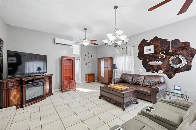 a living room with furniture a chandelier and kitchen view