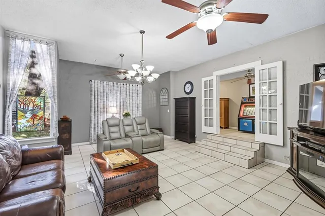 a living room with furniture a chandelier and a flat screen tv