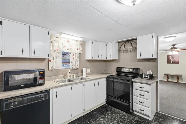 a kitchen with cabinets appliances a sink and a window