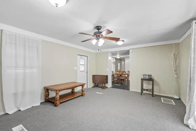 a living room with furniture and a ceiling fan