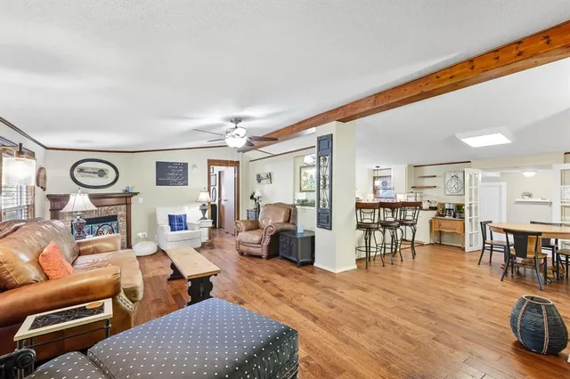 a living room with furniture kitchen view and a large window