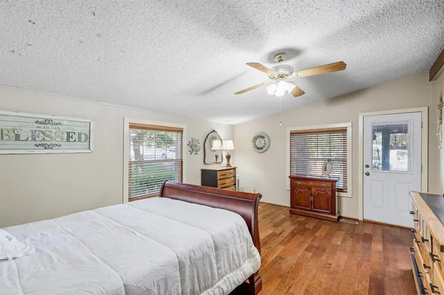 a bedroom with a large bed a chandelier and dresser