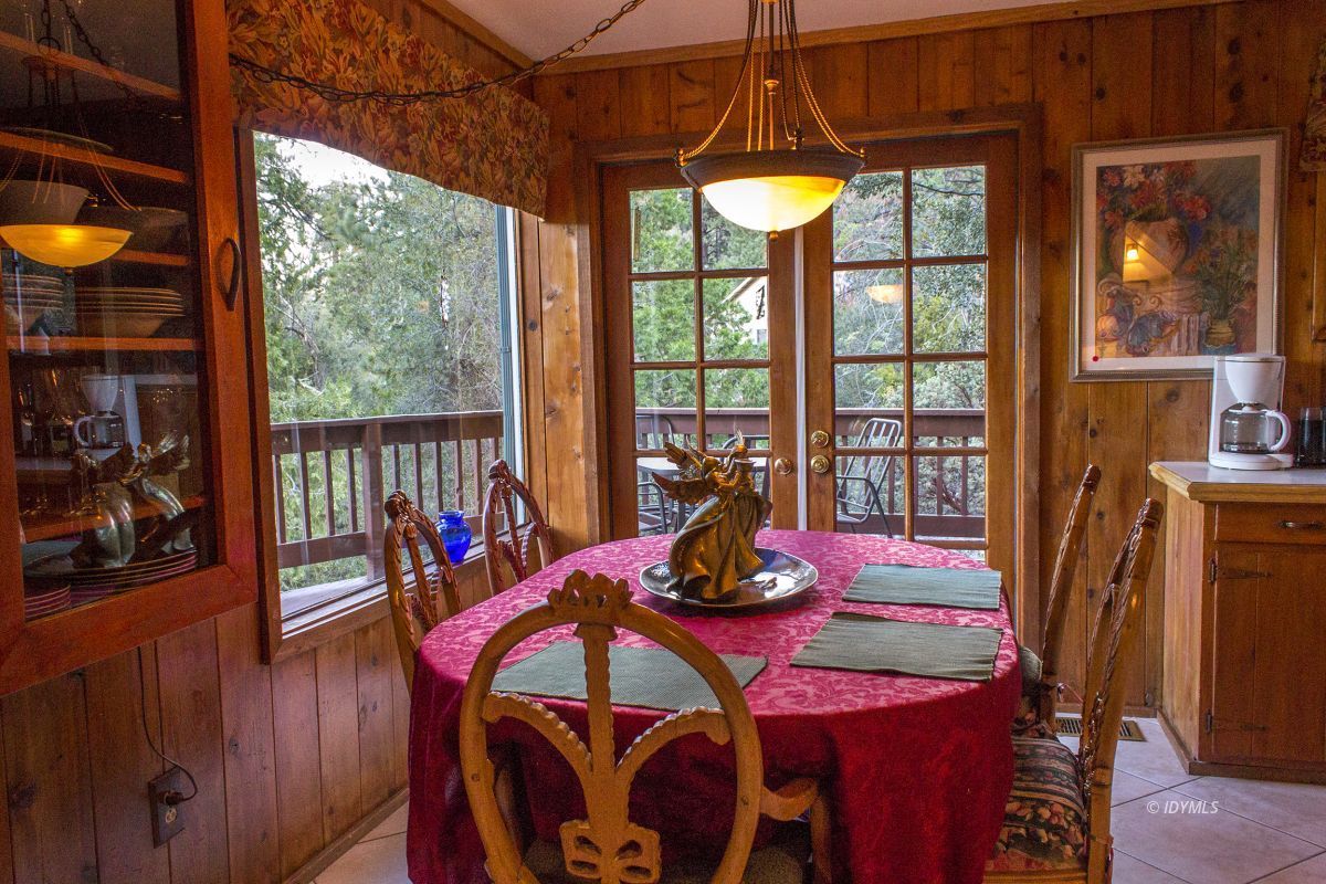 25120 Foster Lake Road Idyllwild, CA 92549 - Photo 12 of 31 a view of a dining room with furniture a chandelier and wooden floor