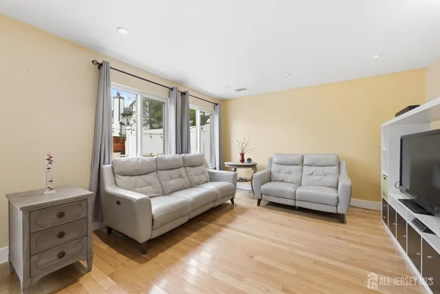 a living room with furniture a flat screen tv and a window