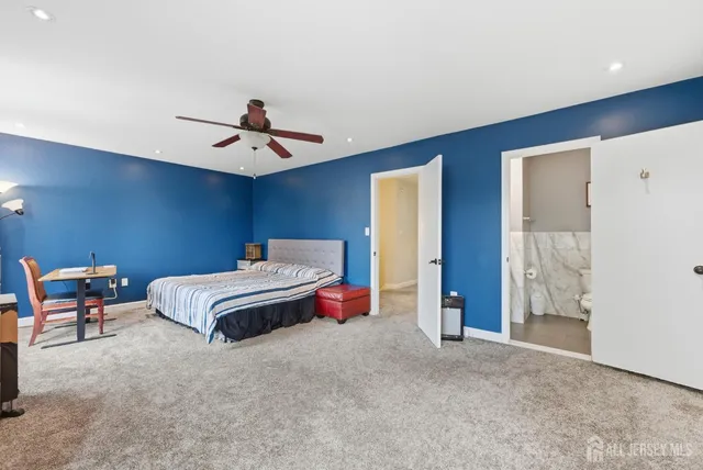 a spacious bedroom with a bed and a ceiling fan