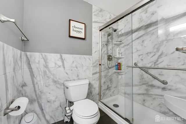 a white toilet sitting next to a bathroom shower