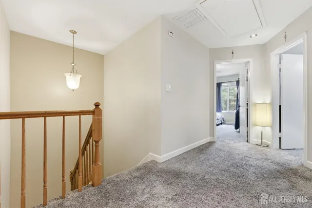 a view of a hallway with wooden floor and stairs
