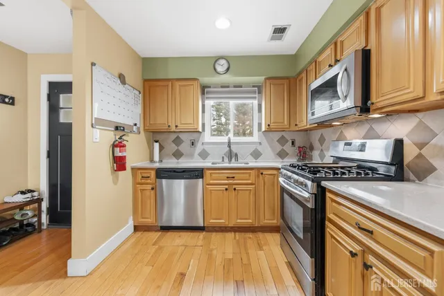 a kitchen with stainless steel appliances granite countertop a stove a sink and a refrigerator