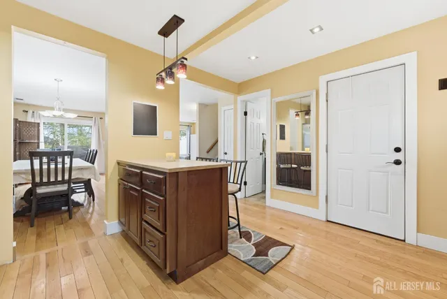 a living room with stainless steel appliances kitchen island granite countertop furniture and a wooden floor
