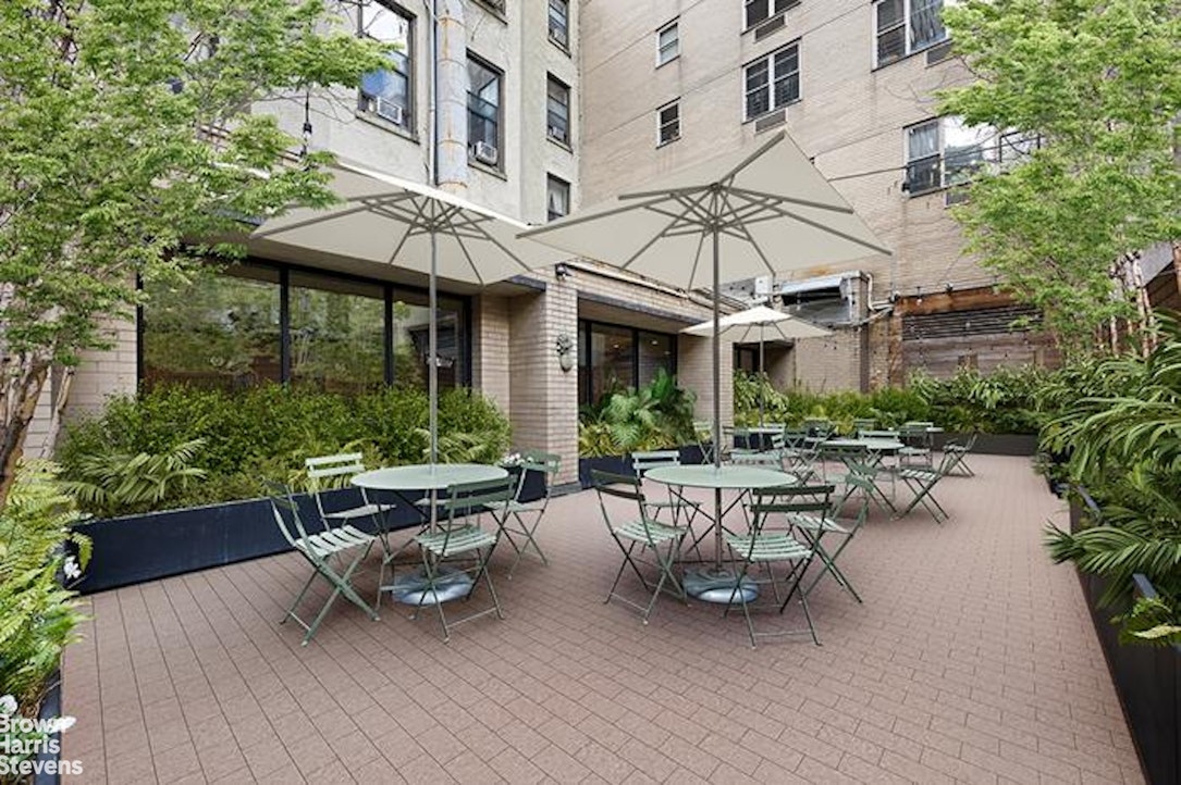 137 East 36th Street, Unit 7K Manhattan, NY 10016 - Photo 11 of 30 a view of a patio with couches table and chairs under an umbrella