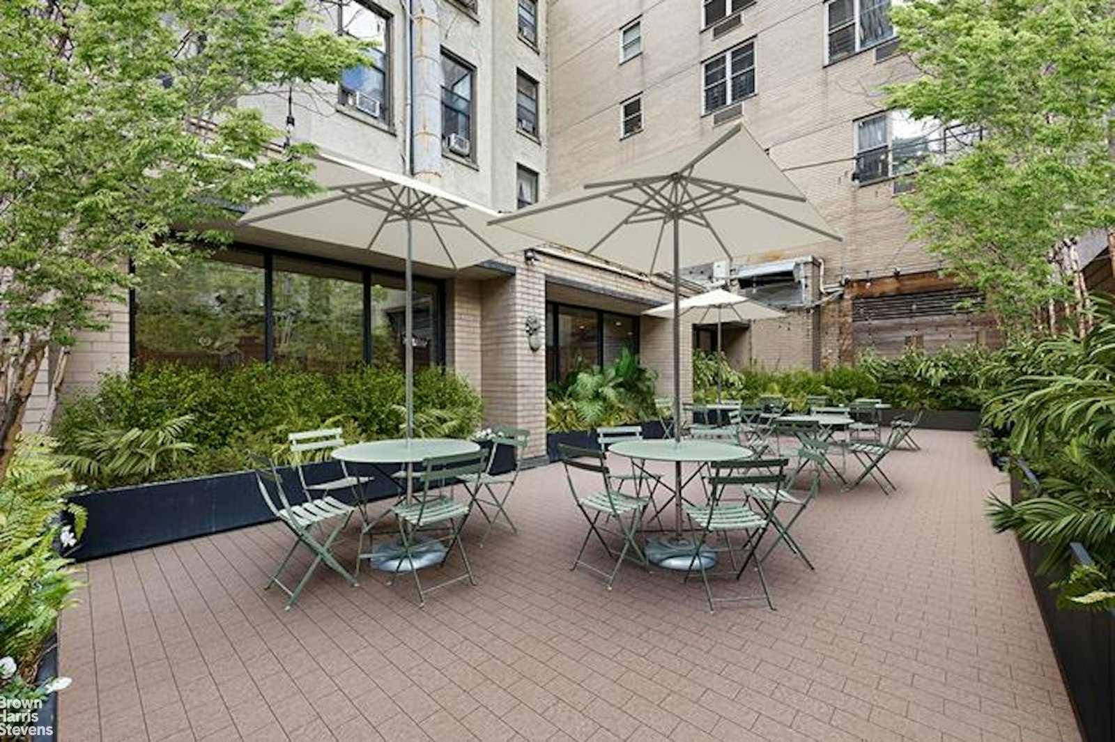 137 East 36th Street, Unit 7K Manhattan, NY 10016 - Photo 24 of 30 a view of a patio with couches table and chairs under an umbrella