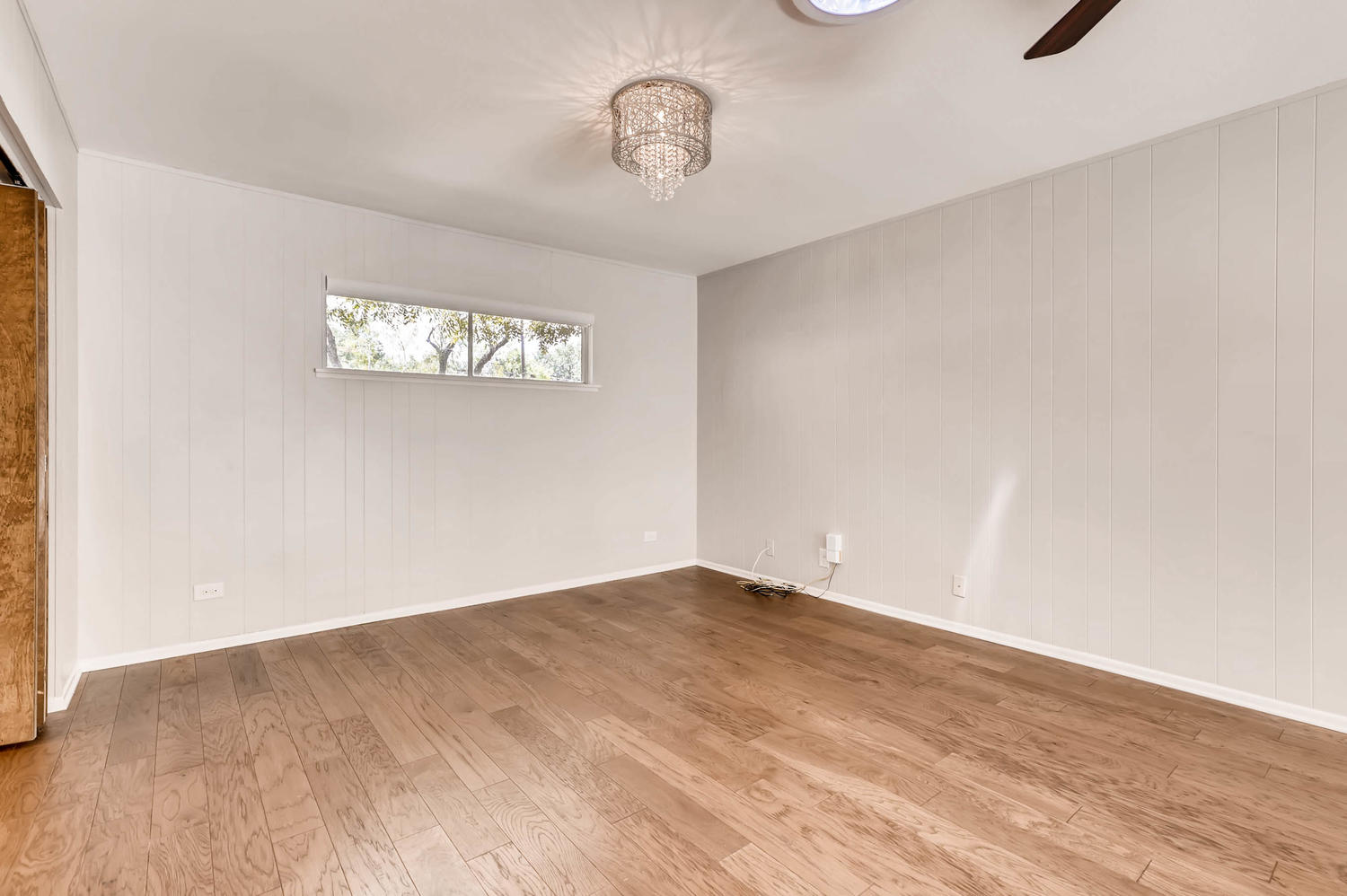 446 Pike Road San Antonio, TX 78209 - Photo 6 of 28 Hardwood floors and a stylish chandelier define this well-lit living area.