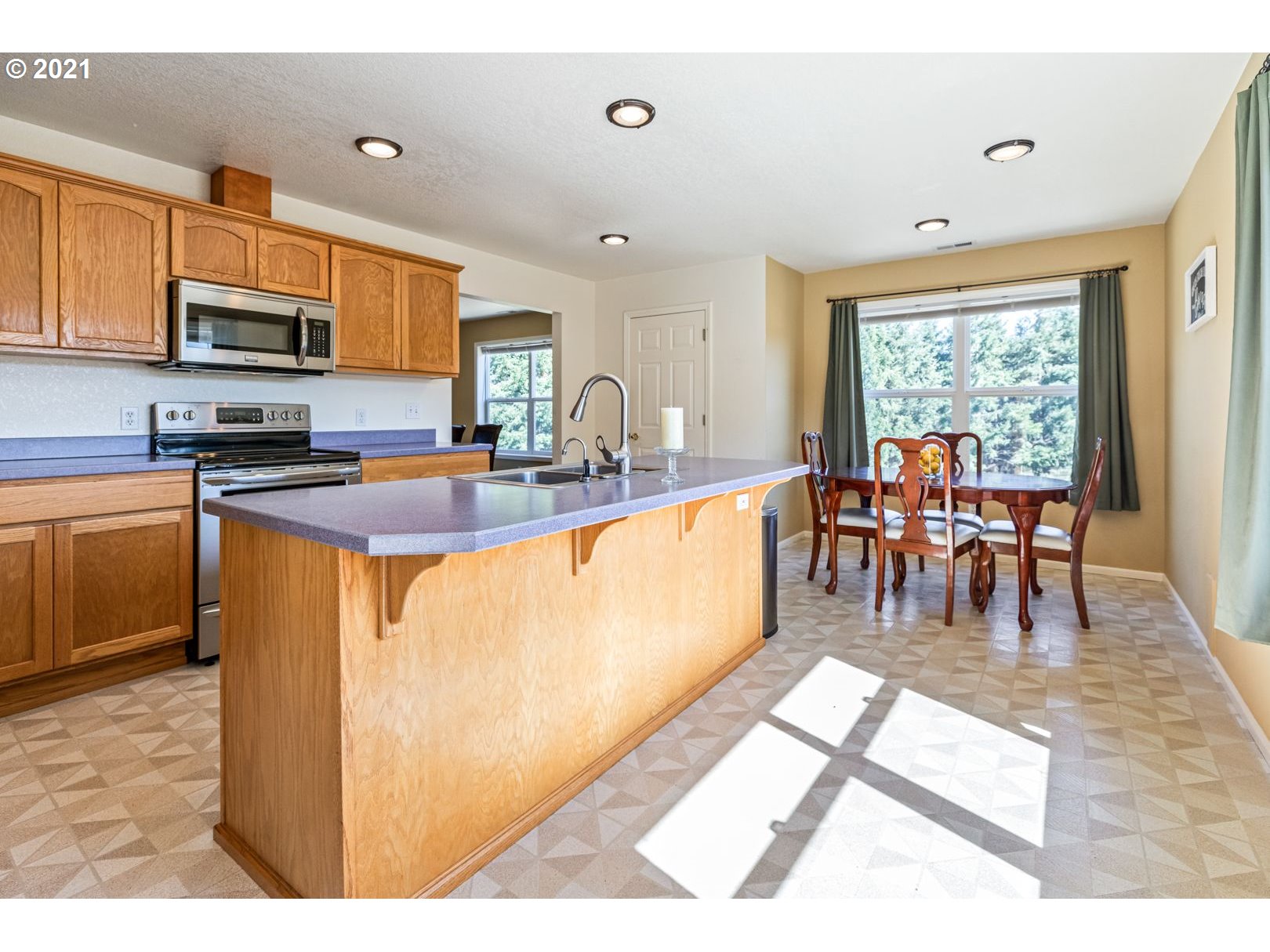 11820 Simpson Road Monmouth, OR 97361 - Photo 5 of 20 a dining hall with stainless steel appliances granite countertop a stove a sink dishwasher a dining table and chairs with wooden floor
