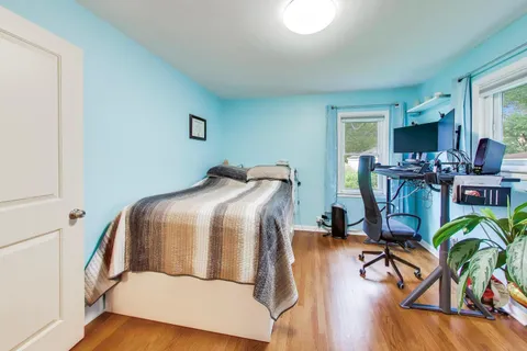 a bedroom with furniture and wooden floor