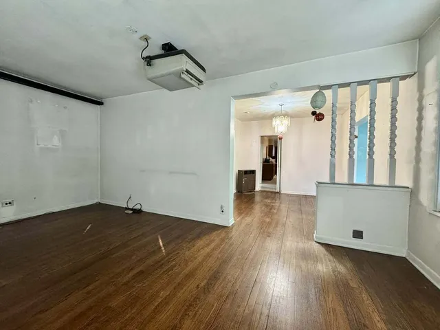 a view of a room with wooden floor and a window