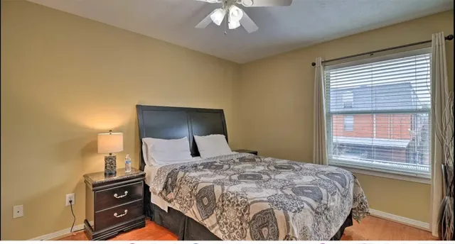 a bedroom with a bed and a lamp on dresser