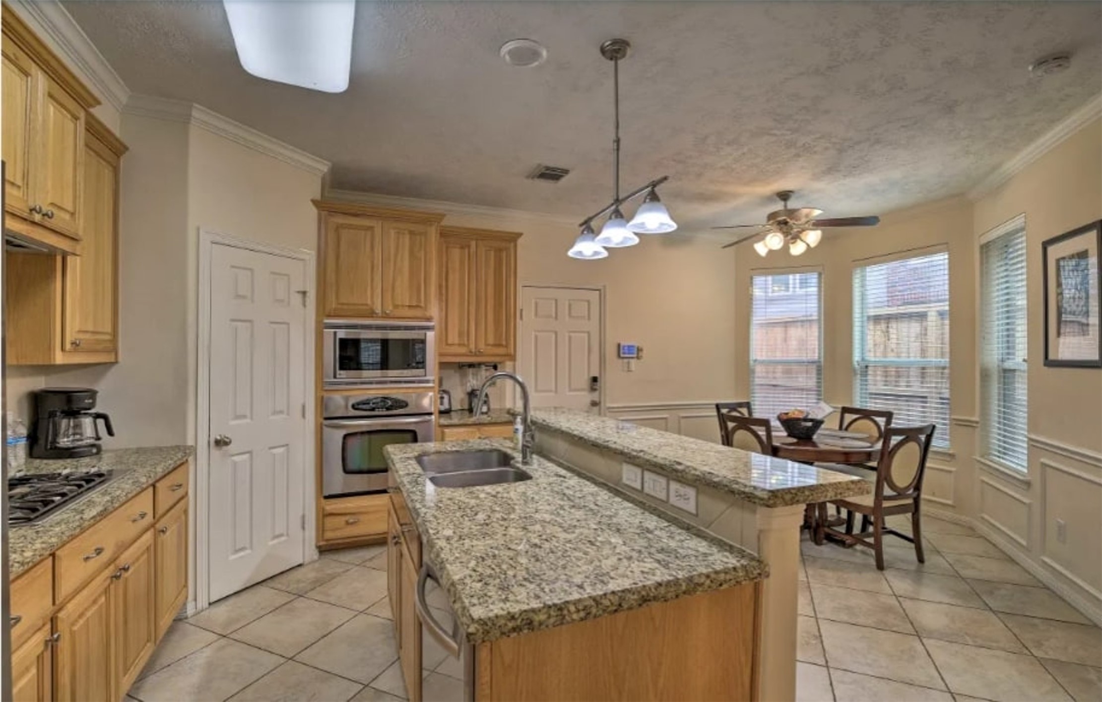 1006 Rochow Street, Unit A Houston, TX 77019 - Photo 6 of 29 a kitchen with granite countertop kitchen island cabinets and stainless steel appliances