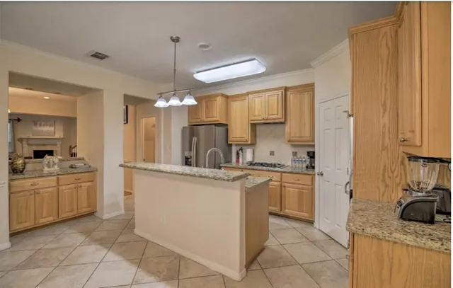 a kitchen with stainless steel appliances granite countertop a sink and a refrigerator