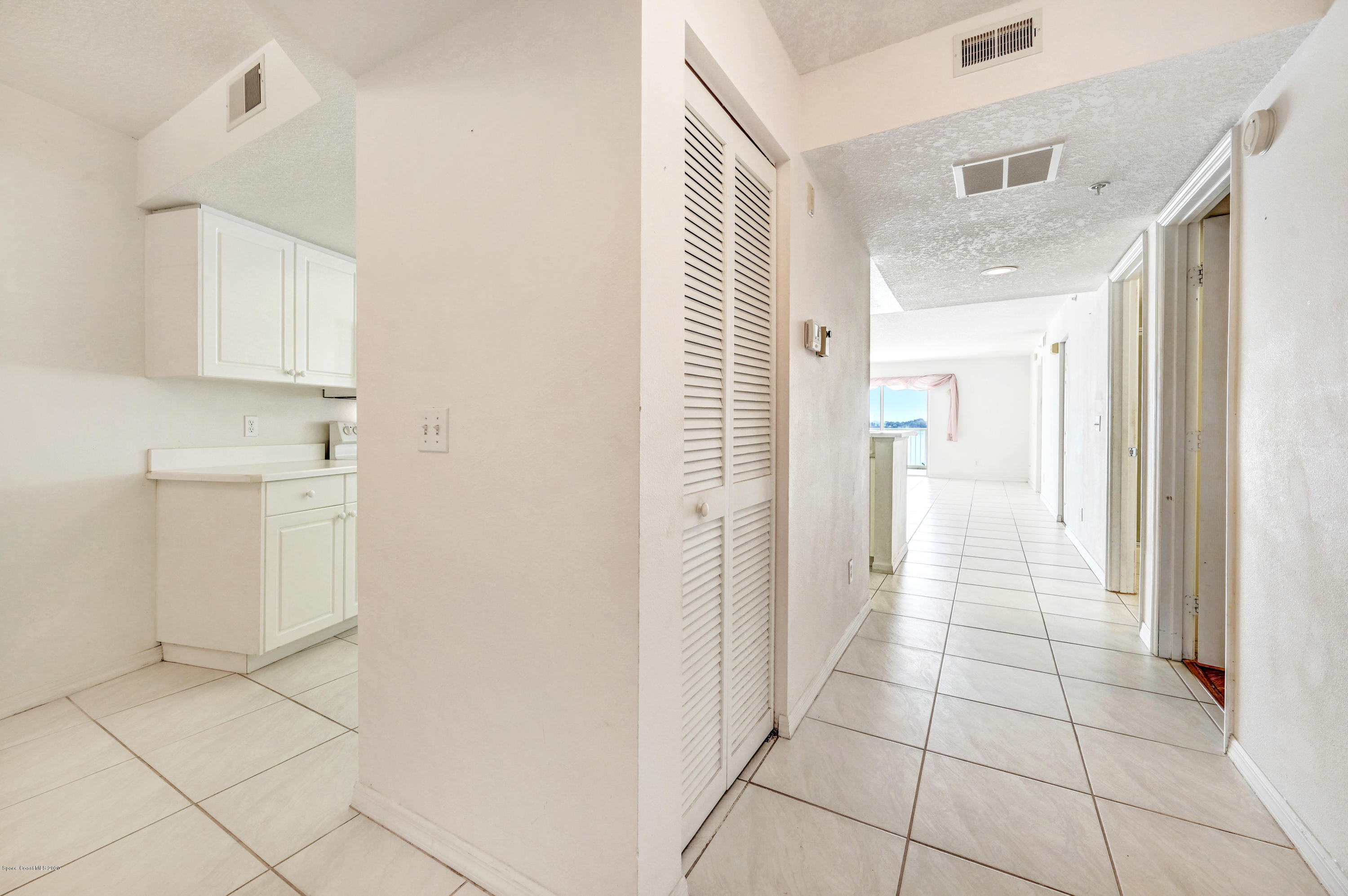 102 Riverside Drive, Unit 304 Cocoa, FL 32922 - Photo 11 of 49 a view of a hallway with white cabinets and a window