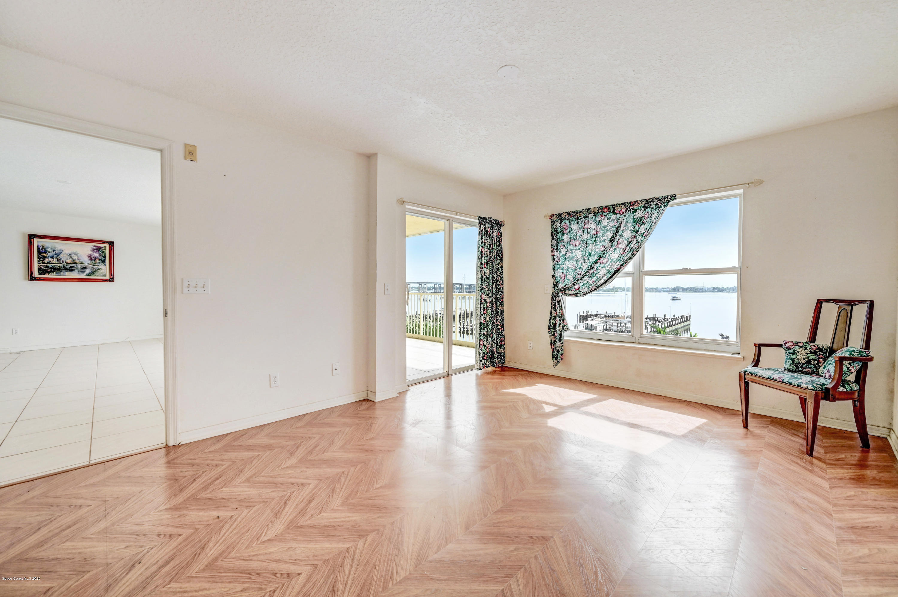 102 Riverside Drive, Unit 304 Cocoa, FL 32922 - Photo 15 of 49 a view of an empty room with a window and wooden floor