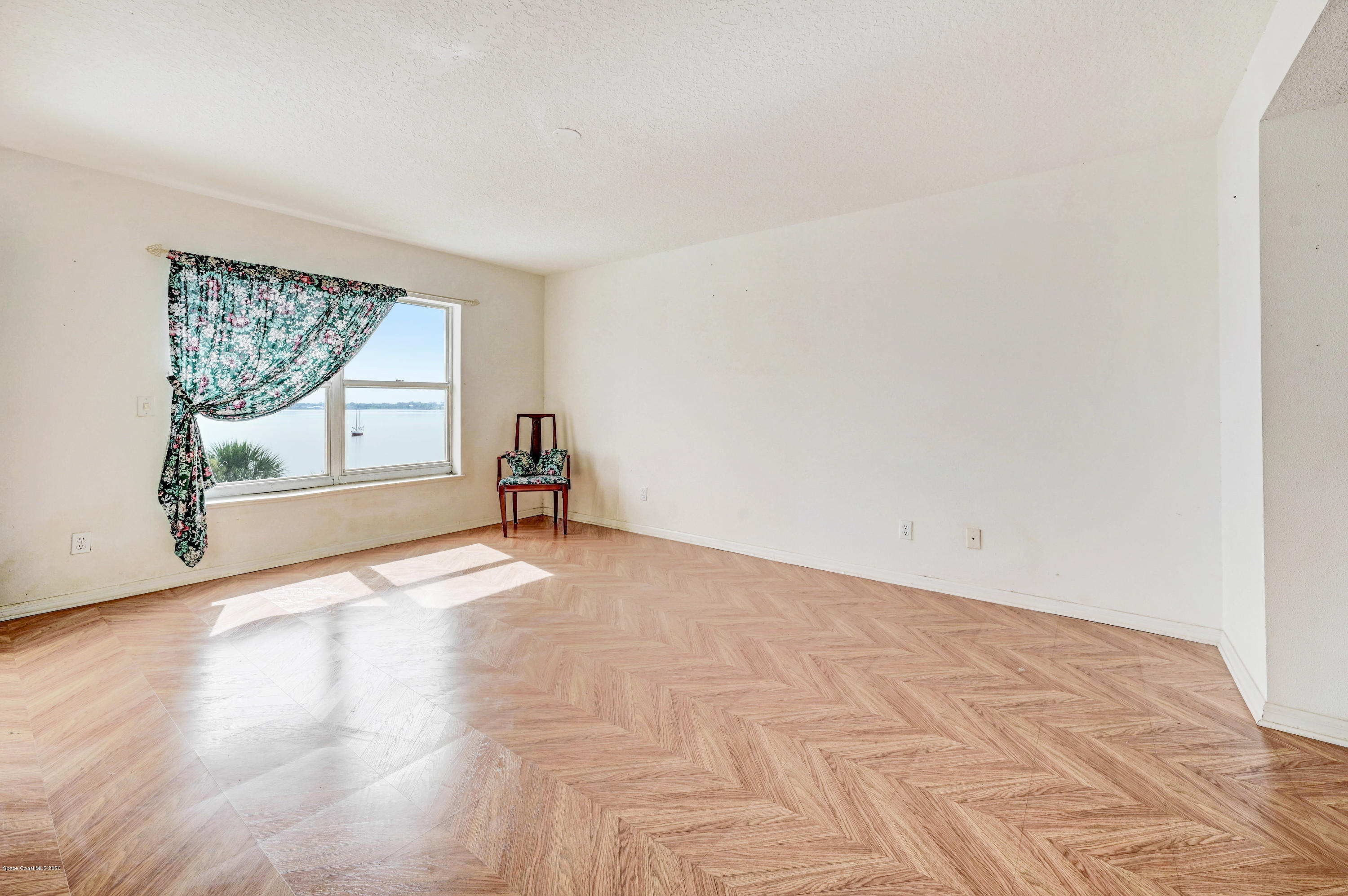 102 Riverside Drive, Unit 304 Cocoa, FL 32922 - Photo 17 of 49 a view of empty room with wooden floor and fan
