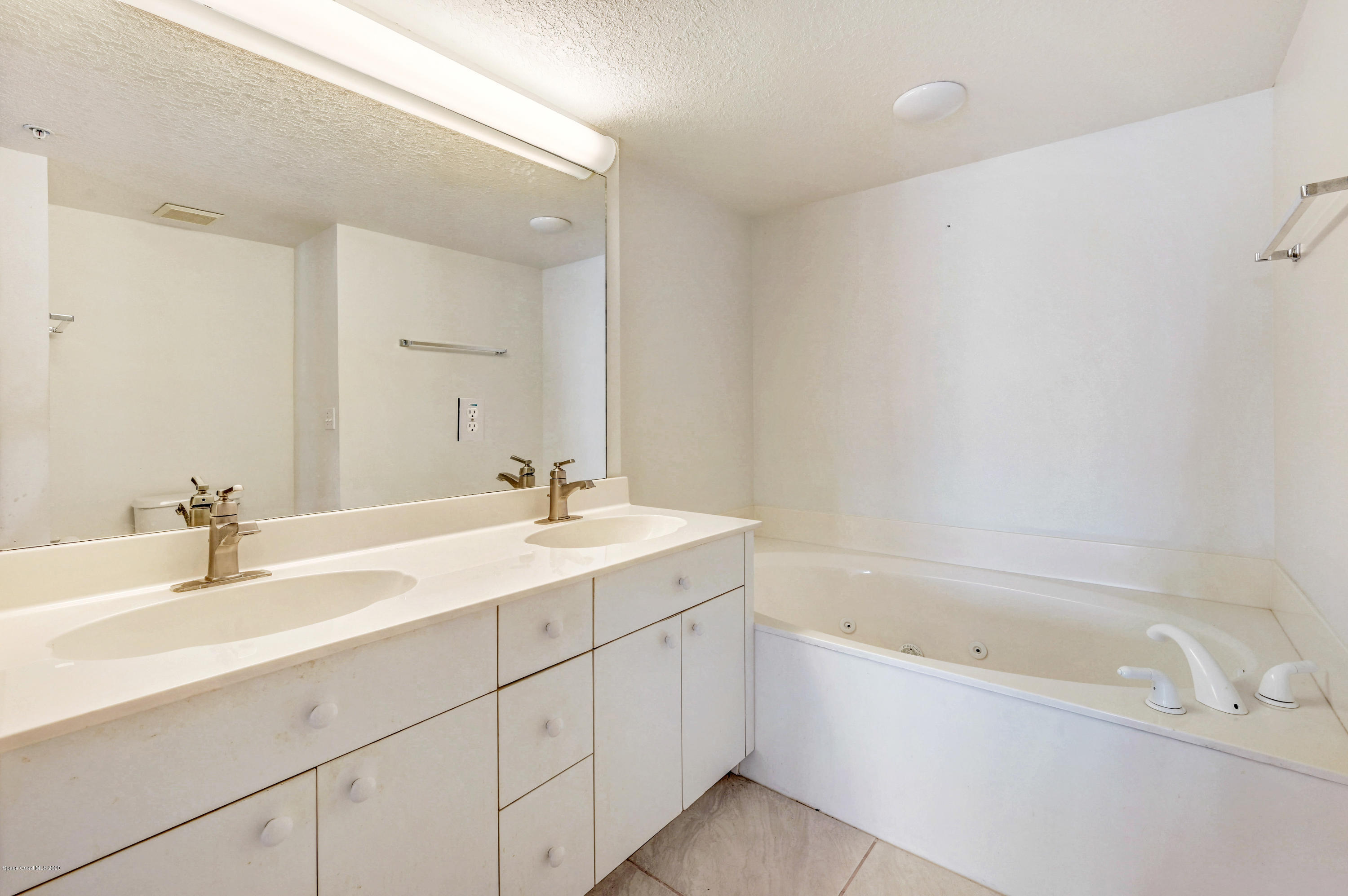102 Riverside Drive, Unit 304 Cocoa, FL 32922 - Photo 20 of 49 a bathroom with a tub sink and mirror