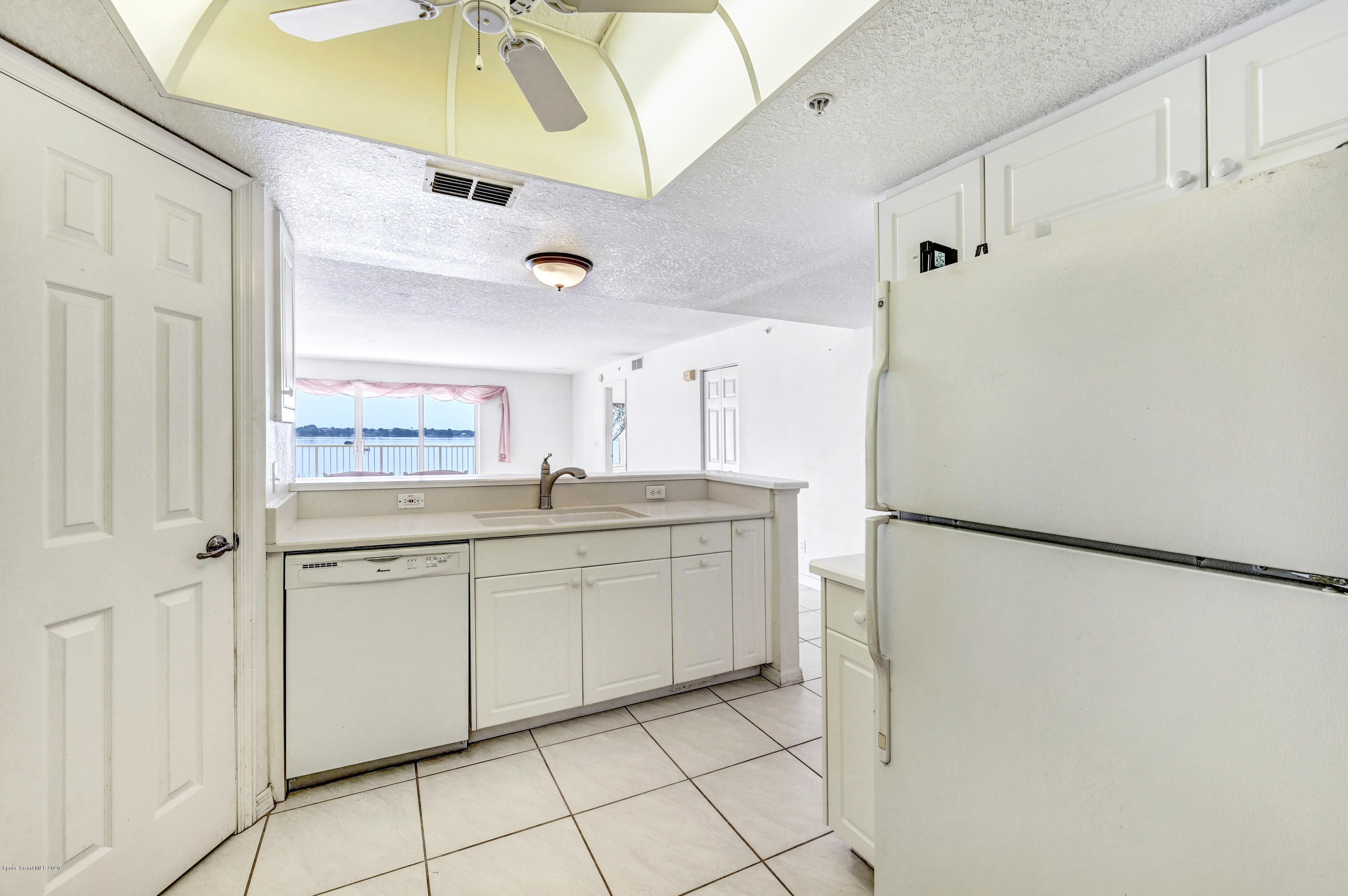 102 Riverside Drive, Unit 304 Cocoa, FL 32922 - Photo 9 of 49 a kitchen with white cabinets and white appliances