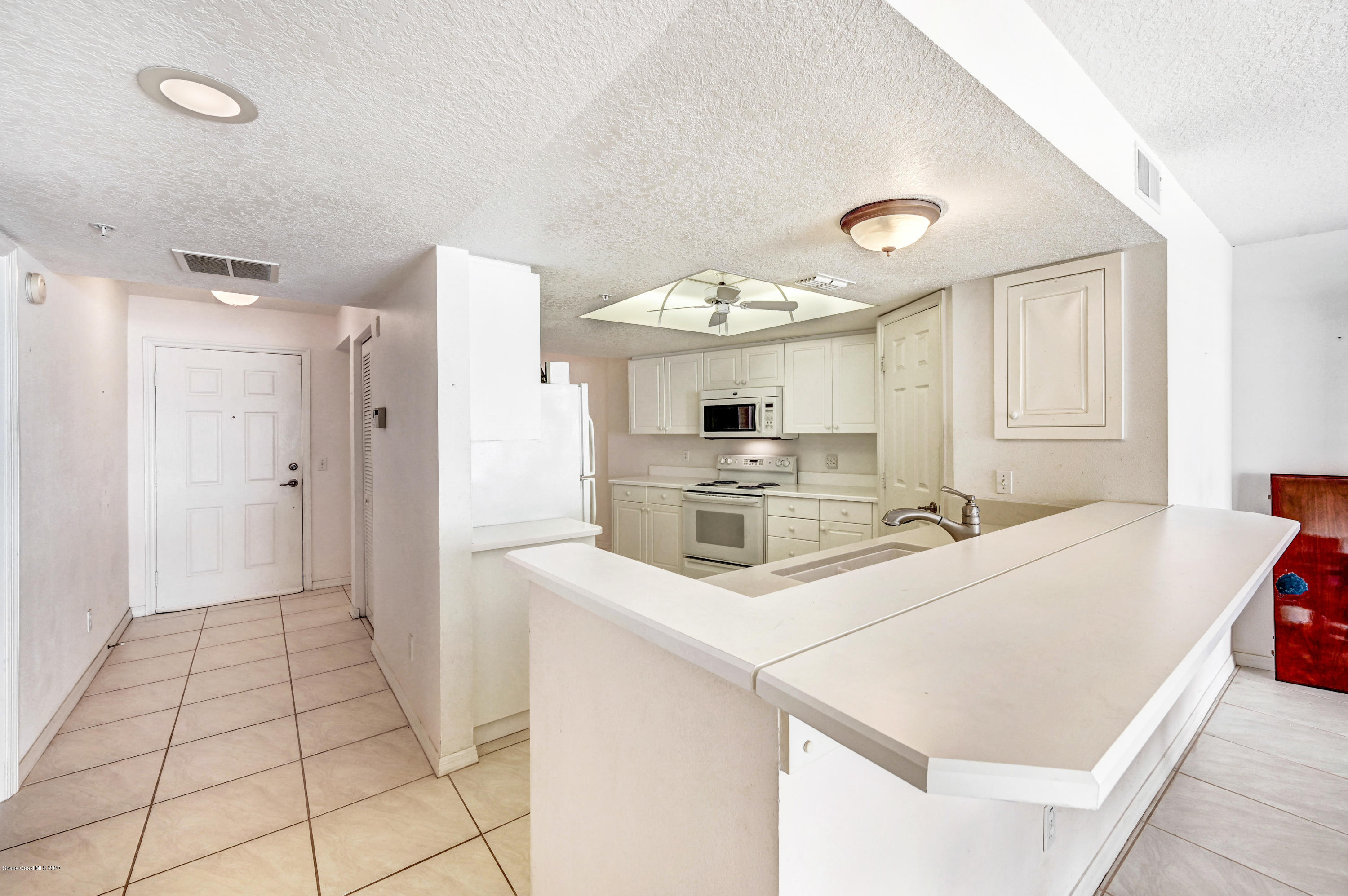 102 Riverside Drive, Unit 304 Cocoa, FL 32922 - Photo 10 of 49 a kitchen with stainless steel appliances a stove a refrigerator and a cabinets
