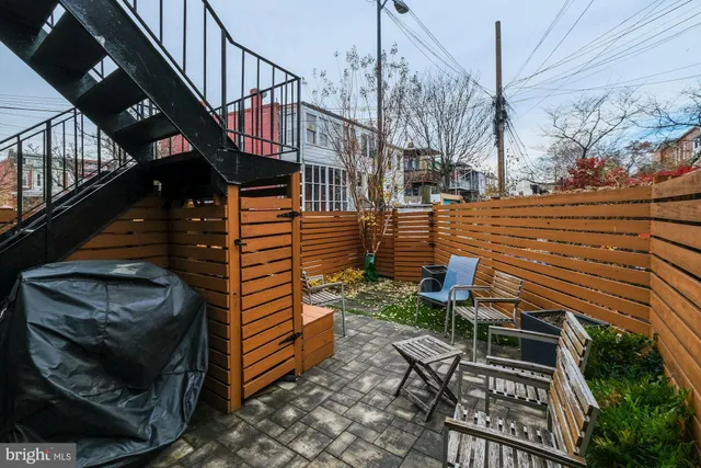 a view of a patio with table and chairs with wooden floor and fence