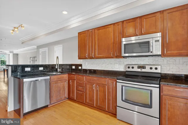a kitchen with stainless steel appliances granite countertop a refrigerator stove top oven and sink