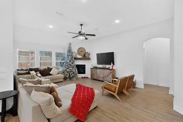 a living room with furniture a flat screen tv and a fireplace