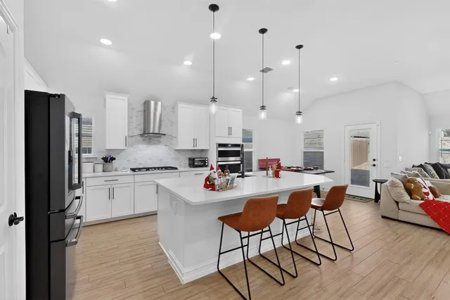 a kitchen with stainless steel appliances kitchen island a refrigerator and a stove top oven