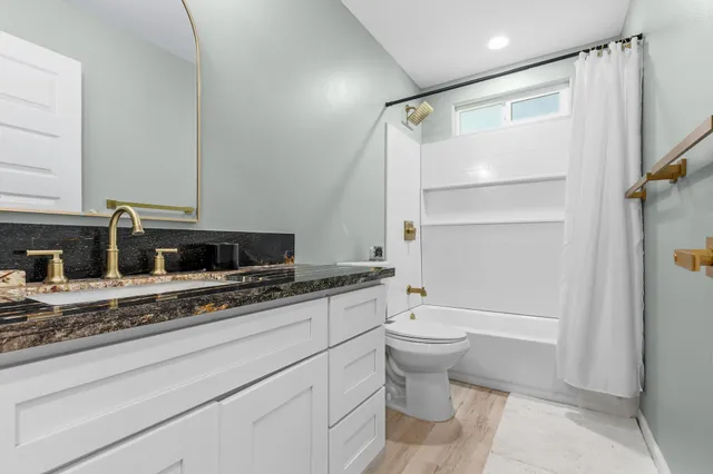 a bathroom with a granite countertop sink toilet and shower
