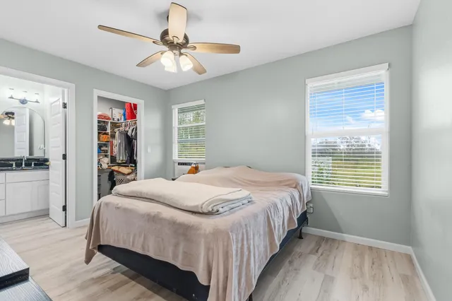 a bedroom with a large bed a chandelier and a window