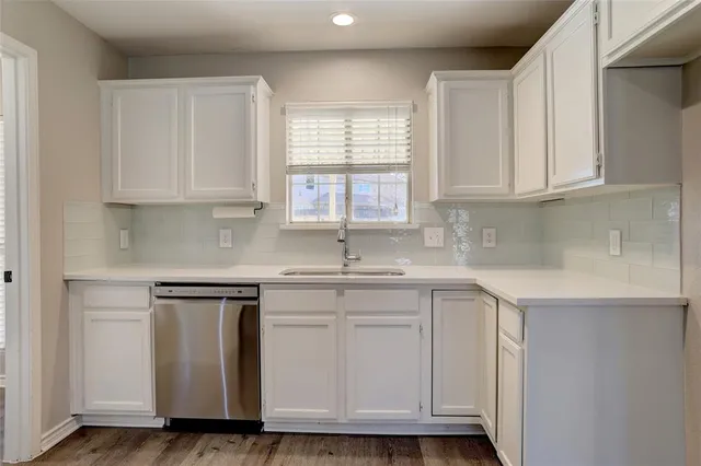 a kitchen with granite countertop white cabinets and a sink