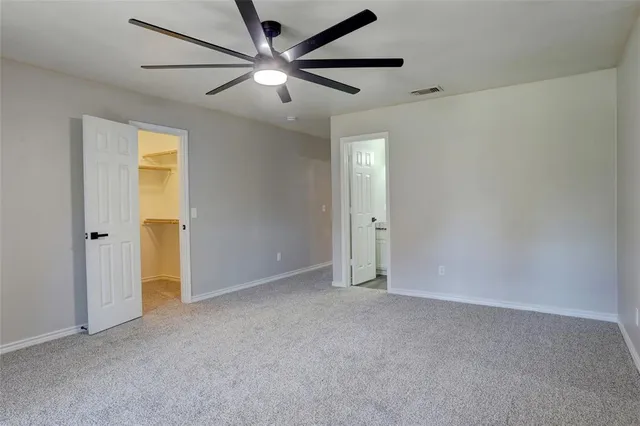 an empty room with a ceiling fan and a window