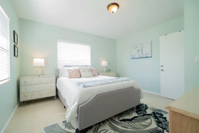 a large bed sitting in a bedroom next to a window