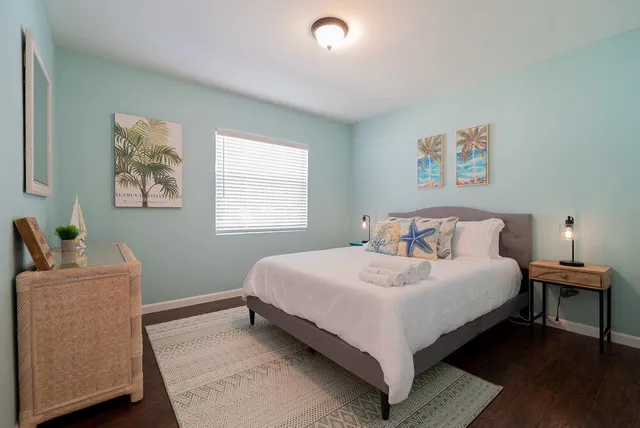 a bedroom with a bed and painting on the wall