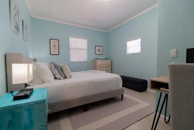 a bedroom with a bed and a lamp on dresser