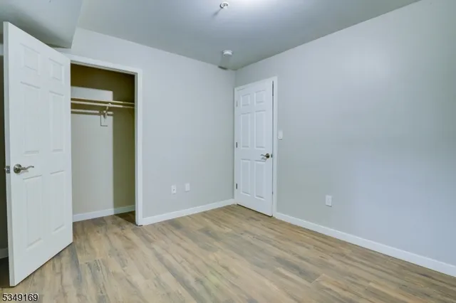 a view of an empty room with closet and a window