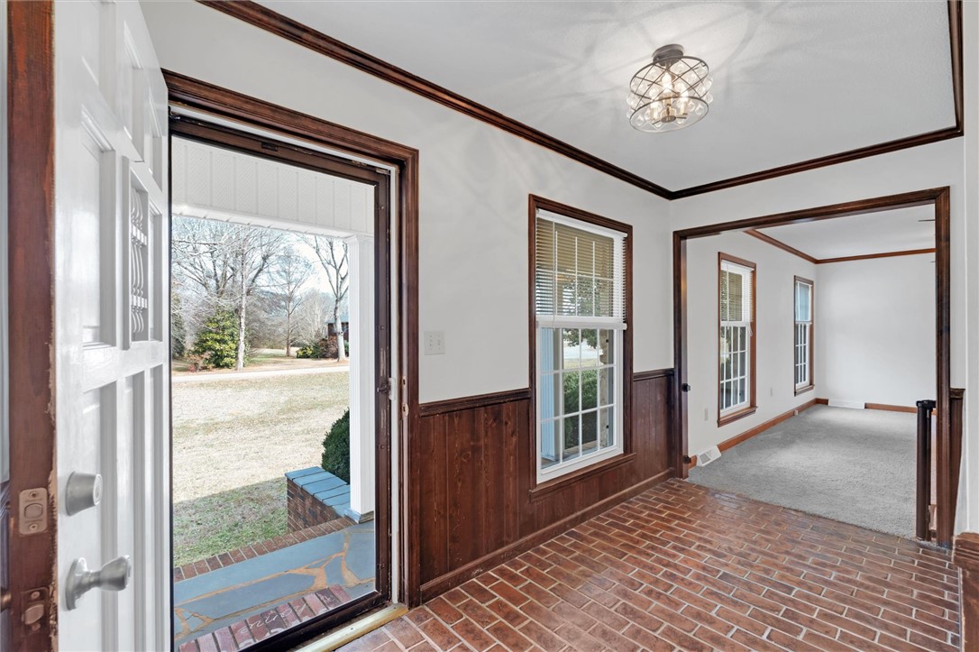2114 Karen Lane Anderson, SC 29626 - Photo 3 of 30 The inviting entryway features durable brick flooring and a classic white door, opening to a bright interior.