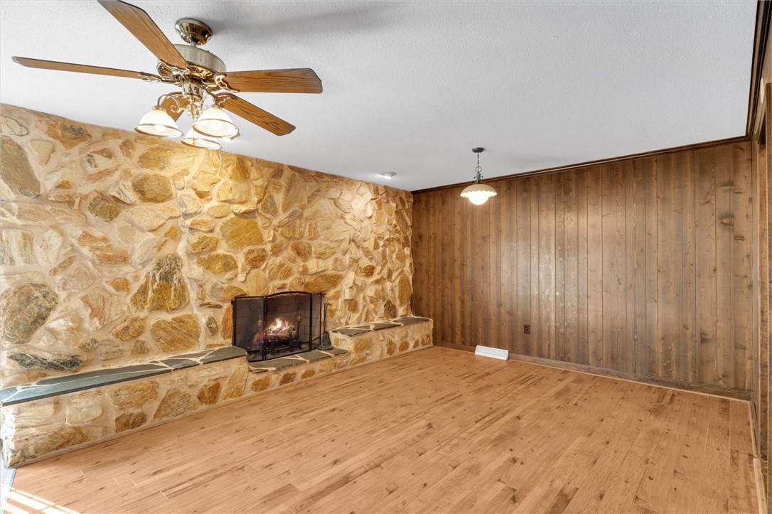 2114 Karen Lane Anderson, SC 29626 - Photo 6 of 30 This inviting room features a natural stone fireplace and warm wood paneling, creating a cozy atmosphere.