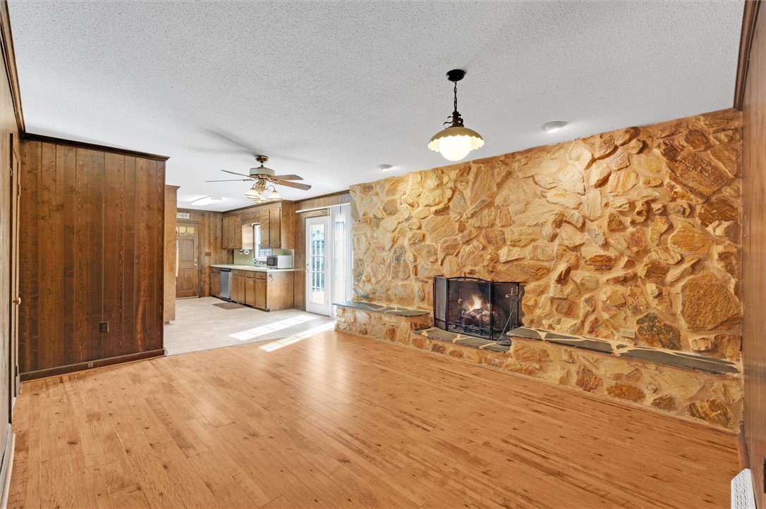 2114 Karen Lane Anderson, SC 29626 - Photo 7 of 30 This inviting interior features a rustic fireplace and warm wood paneling, ideal for cozy gatherings.