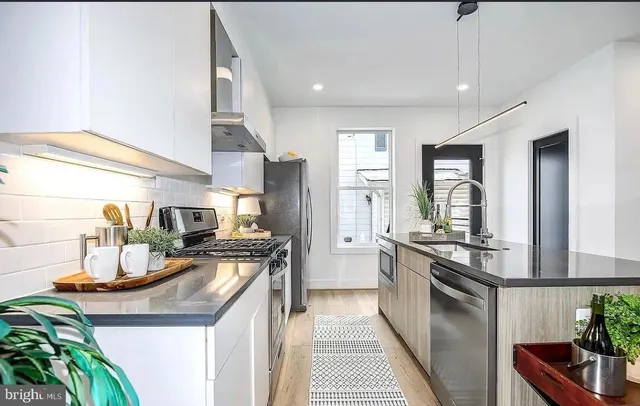 a kitchen with sink stove and refrigerator