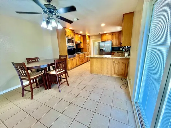 a living room with stainless steel appliances kitchen island granite countertop a sink and cabinets