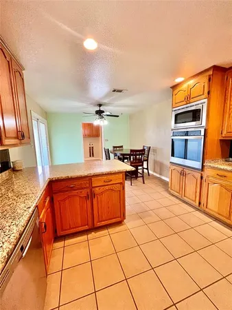 a kitchen with stainless steel appliances granite countertop a stove a sink and a microwave