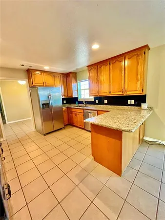 a kitchen with stainless steel appliances kitchen island granite countertop a refrigerator and stove