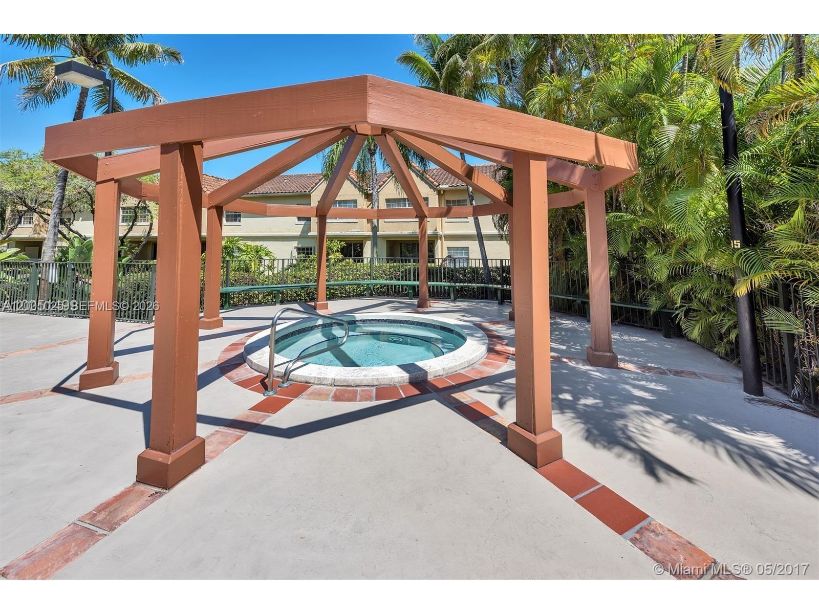 18310 Northwest 68th Avenue, Unit L Hialeah, FL 33015 - Photo 19 of 21 a view of a patio with table and chairs under an umbrella